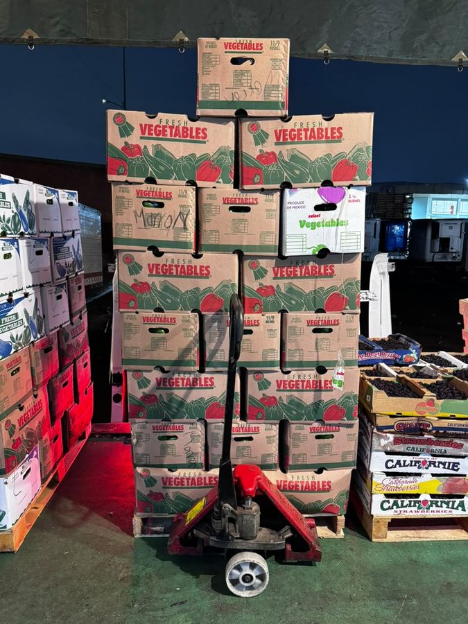 Tarima con cajas de verdura y patín hidráulico